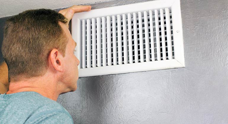 man inspecting air duct